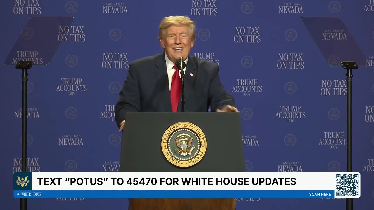 President Donald Trump smiles behind a lectern during remarks in Las Vegas, with No Tax on Tips and Trump Accounts signs behind him.